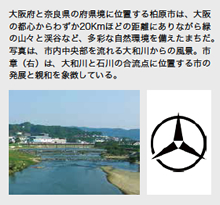 大阪府と奈良県の府県境に位置する柏原市は、大阪の都心からわずか20Kmほどの距離にありながら緑の山々と渓谷など、多彩な自然環境を備えたまちだ。写真は、市内中央部を流れる大和川からの風景。市章（右）は、大和川と石川の合流点に位置する市の発展と親和を象徴している。